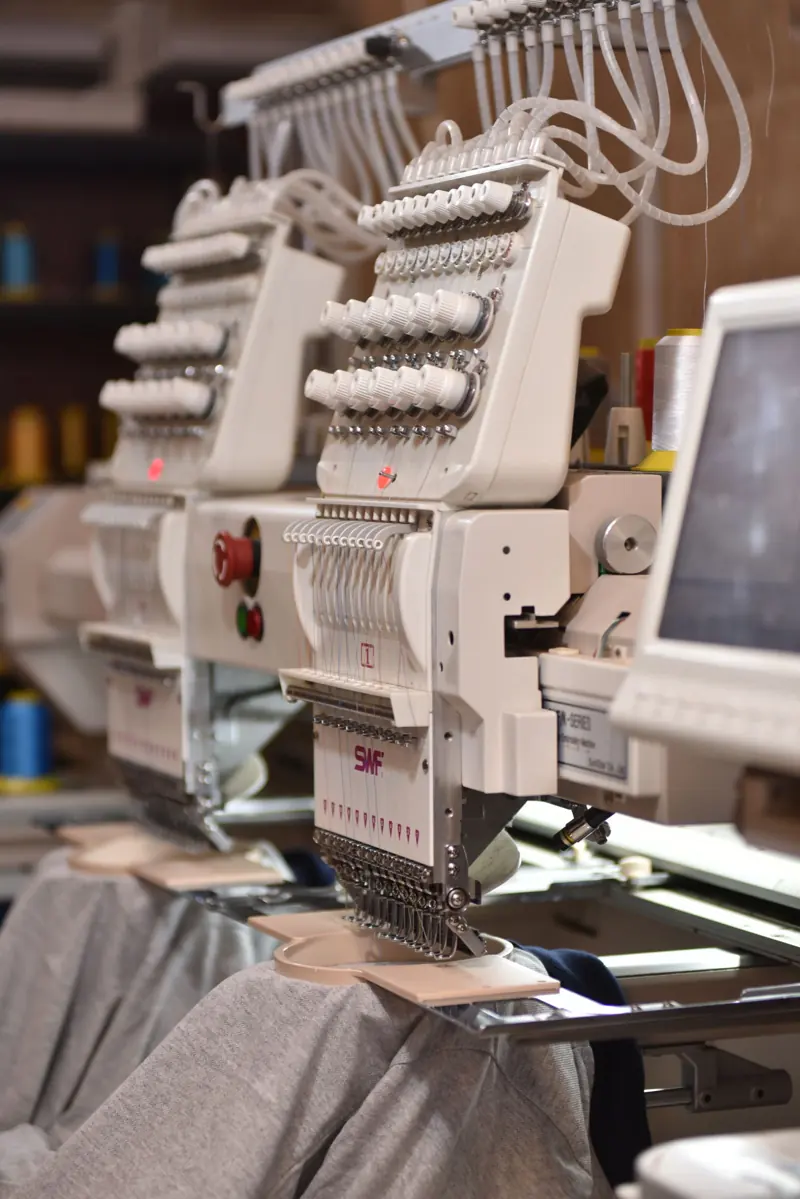 Close-up of commercial embroidery machine heads and needles