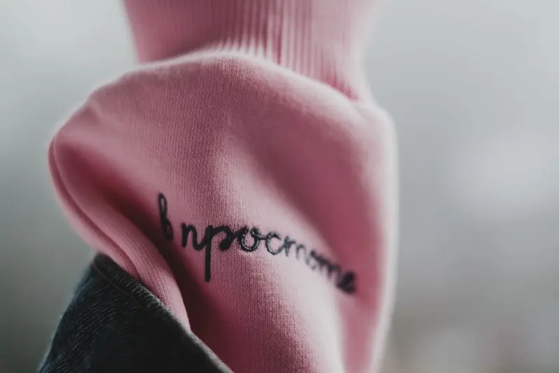 Script lettering embroidered on a knit sleeve